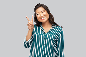 Image showing happy asian woman showing peace hand sign