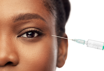 Image showing close up of face of african woman and syringe