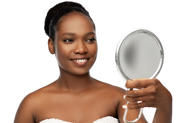 Image showing smiling african american woman looking to mirror