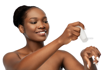 Image showing smiling african american woman with moisturizer