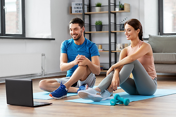 Image showing happy couple with laptop doing sports at home