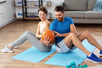 Image showing happy couple exercising with ball at home