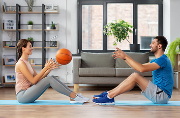 Image showing happy couple exercising with ball at home