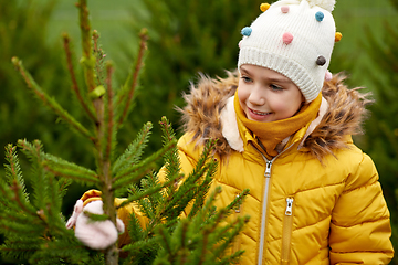 Image showing little girl choosing christmas tree at market