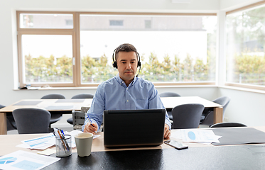 Image showing man with headset and laptop working at home