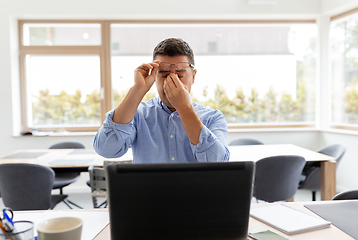 Image showing tired man with laptop working at home office