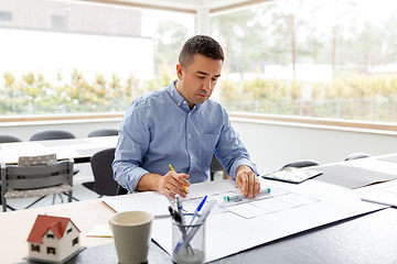 Image showing architect with blueprint working at home office