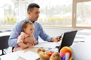 Image showing father with baby and smartphone working at home