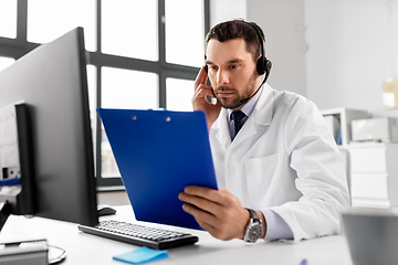 Image showing male doctor with headset and clipboard at hospital