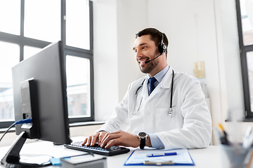 Image showing happy doctor with computer and headset at hospital