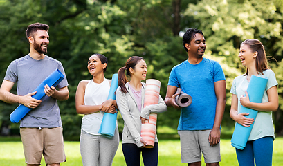 Image showing group of happy people with yoga mats at park