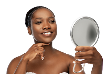 Image showing smiling african american woman looking to mirror