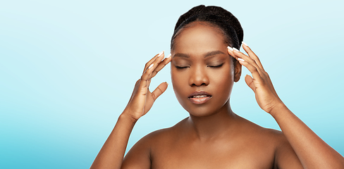 Image showing portrait of african woman doing face massage