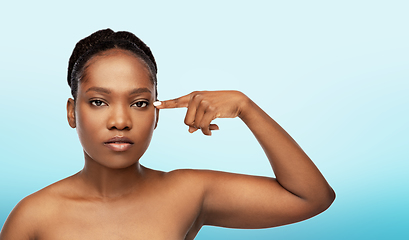 Image showing beautiful african woman pointing to her eye