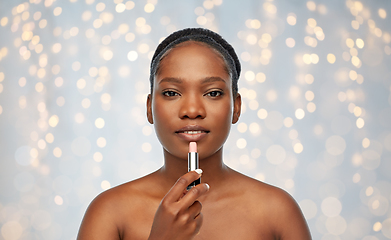 Image showing african american woman applying lipstick