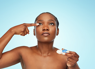 Image showing african american woman putting on contact lenses