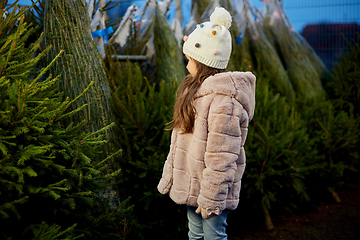 Image showing little girl choosing christmas tree at market