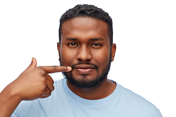 Image showing african american man pointing finger to his mouth