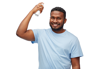 Image showing african american man applying hairspray to hair