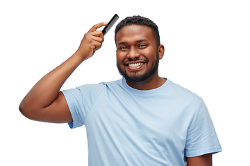 Image showing happy african american man brushing hair with comb