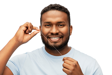 Image showing happy african man with dental floss cleaning teeth