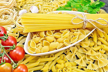 Image showing Pasta different with bowl and tomatoes on dark board