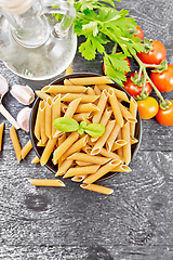 Image showing Penne whole grain in bowl with vegetables on dark board top