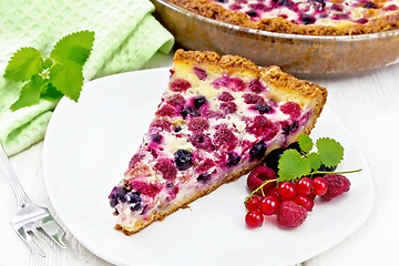 Image showing Pie with raspberries and currants in plate on wooden board