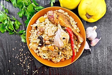 Image showing Pilaf with duck and quince in plate on board top