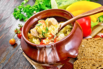 Image showing Rice with chicken and vegetables in pot on board