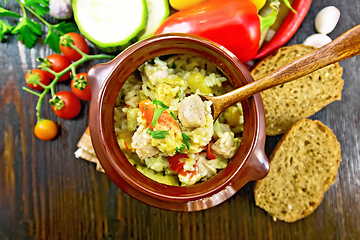 Image showing Rice with chicken and vegetables in pot on dark board top