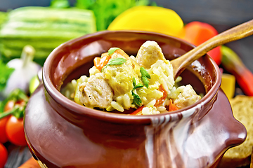 Image showing Rice with chicken and vegetables in pot on dark board