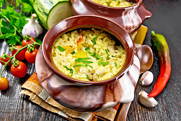 Image showing Rice with chicken and vegetables in two pots on dark board