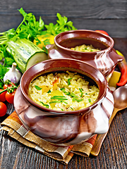 Image showing Rice with chicken and vegetables in two pots on towel