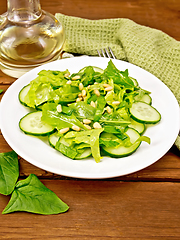 Image showing Salad from spinach and cucumbers with napkin on table