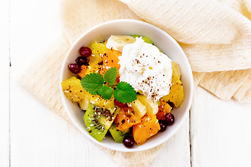 Image showing Salad fruit with cranberries and cream in bowl on board top