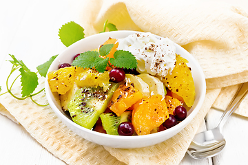 Image showing Salad fruit with cranberries and cream in bowl on board