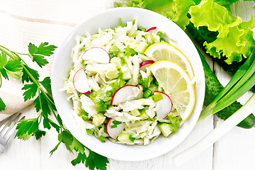 Image showing Salad of cabbage with radish in plate on board top