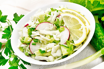 Image showing Salad of cabbage with radish in plate on white board