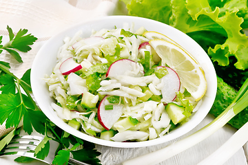 Image showing Salad of cabbage with radish in plate on wooden board