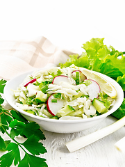 Image showing Salad of cabbage with radish in plate on wooden table