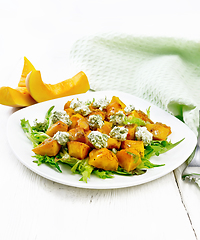 Image showing Salad of pumpkin and cheese in plate on light wooden board