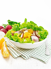 Image showing Salad of radish and orange with mint on wooden board