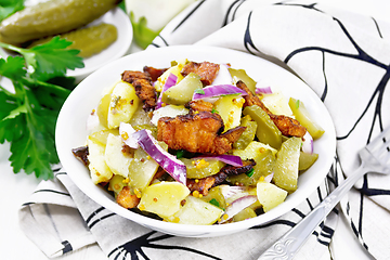 Image showing Salad potato with bacon and cucumber in plate on board