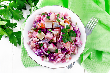Image showing Salad with herring and beetroot in bowl on board top