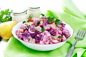 Image showing Salad with herring and beetroot in bowl on board