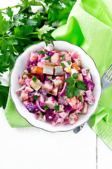Image showing Salad with herring and beetroot in bowl on light board top