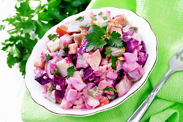 Image showing Salad with herring and beetroot in bowl on light board