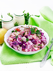 Image showing Salad with herring and beetroot in bowl on napkin