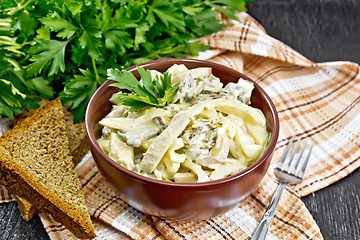 Image showing Salad with squid and champignons in bowl on dark board